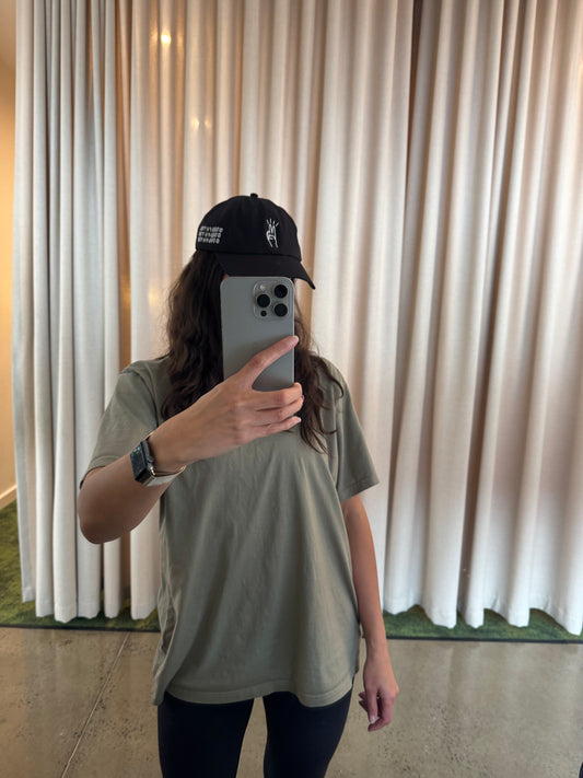 Person wearing a good physio cap and taking a mirror selfie in front of white curtains.
